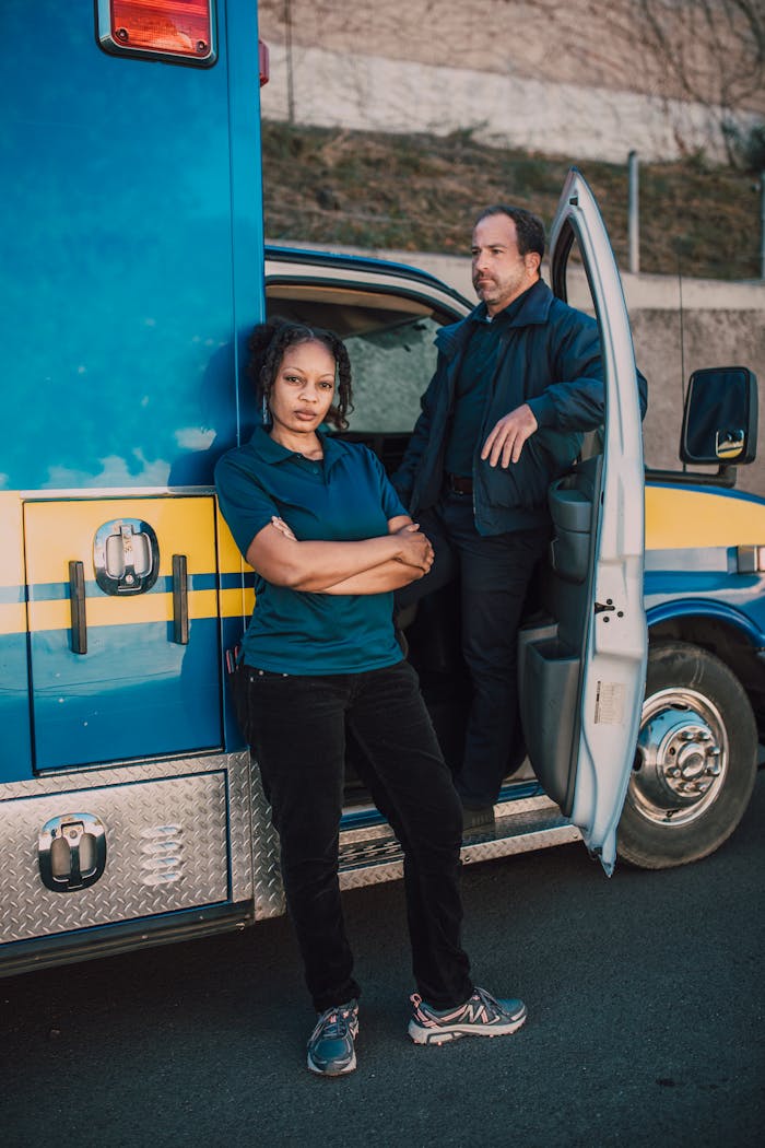 Two EMTs standing by an ambulance, ready for emergency response.